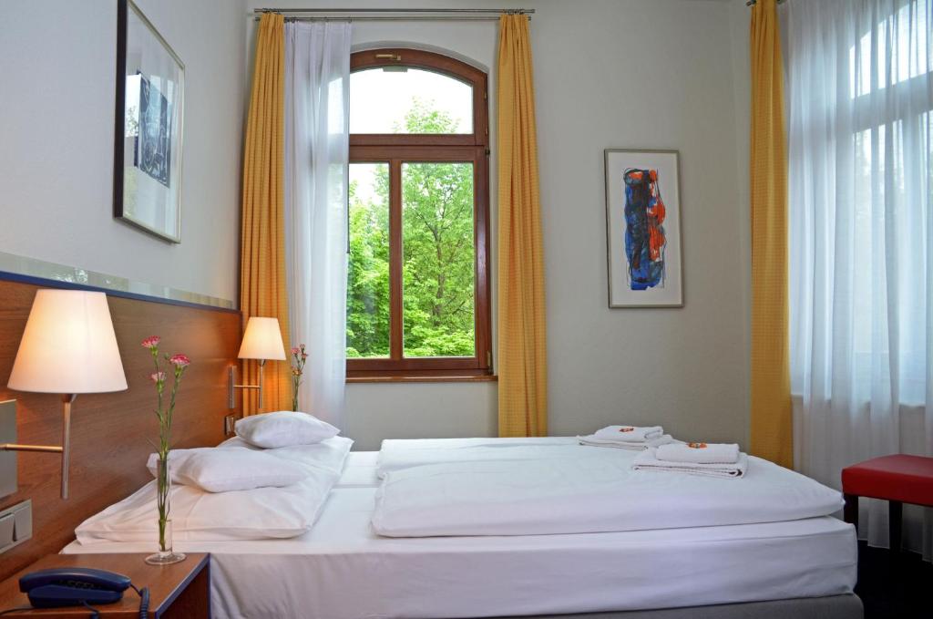 魏玛包豪斯弗斯特霍夫公寓式酒店&酒店的卧室配有一张大白色床和窗户