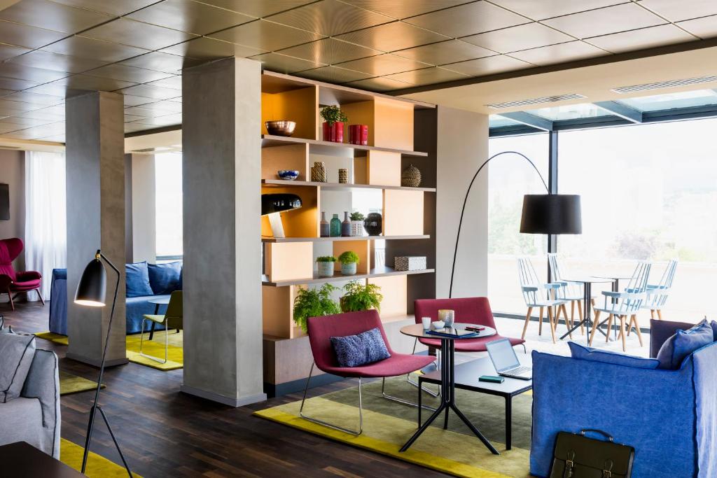 吕埃尔-马尔迈松巴黎吕埃马尔梅松酒店的客厅配有五颜六色的椅子和桌子