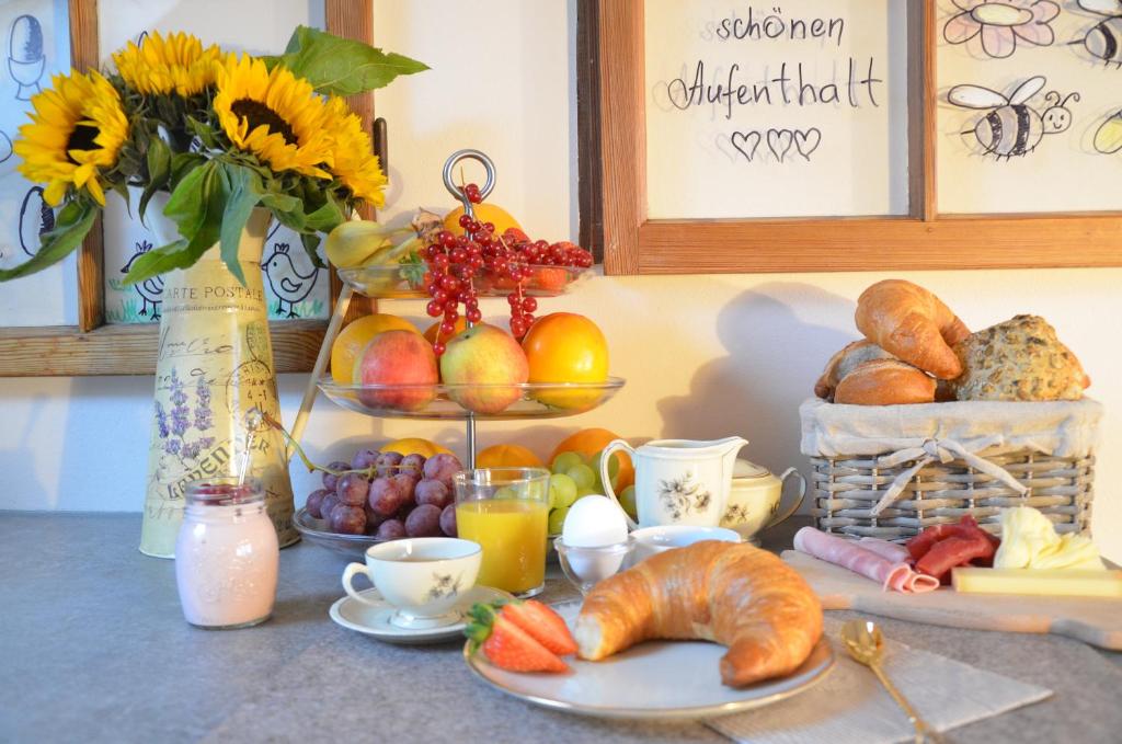 诺特维尔弗里多住宿加早餐旅馆的包括羊角面包、鸡蛋和花瓶的早餐桌