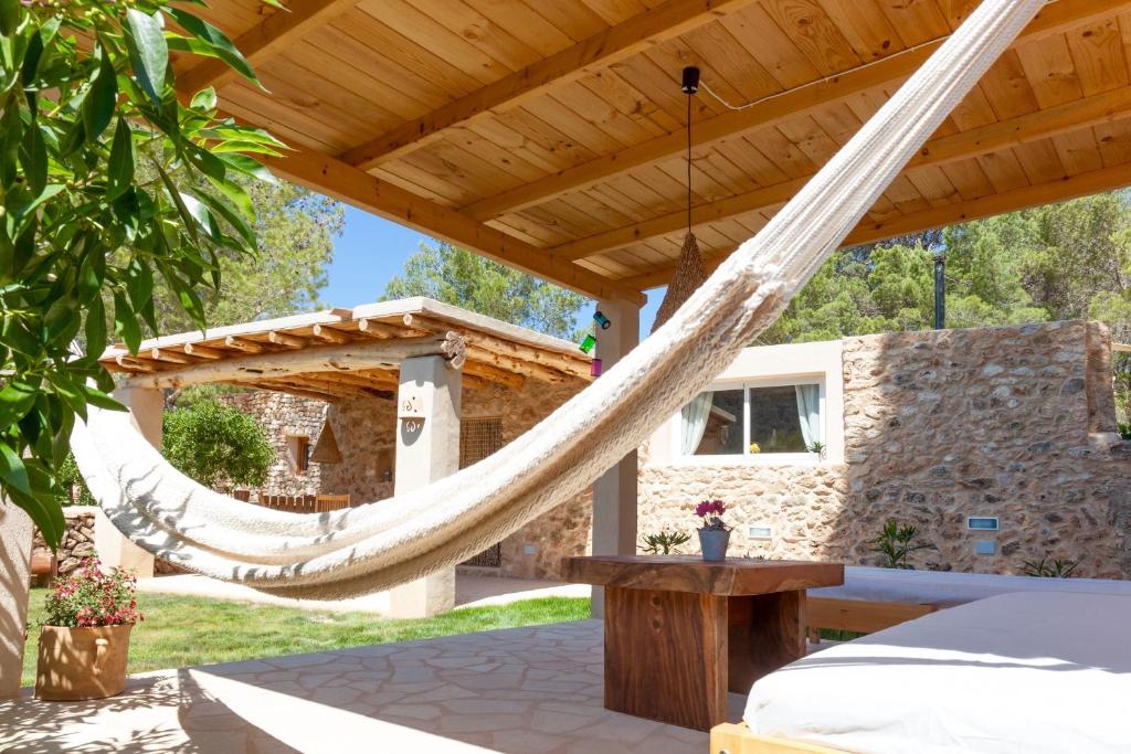 卡拉瓦德亚Villa Es Coral的一个带吊床的庭院,位于木制凉棚下