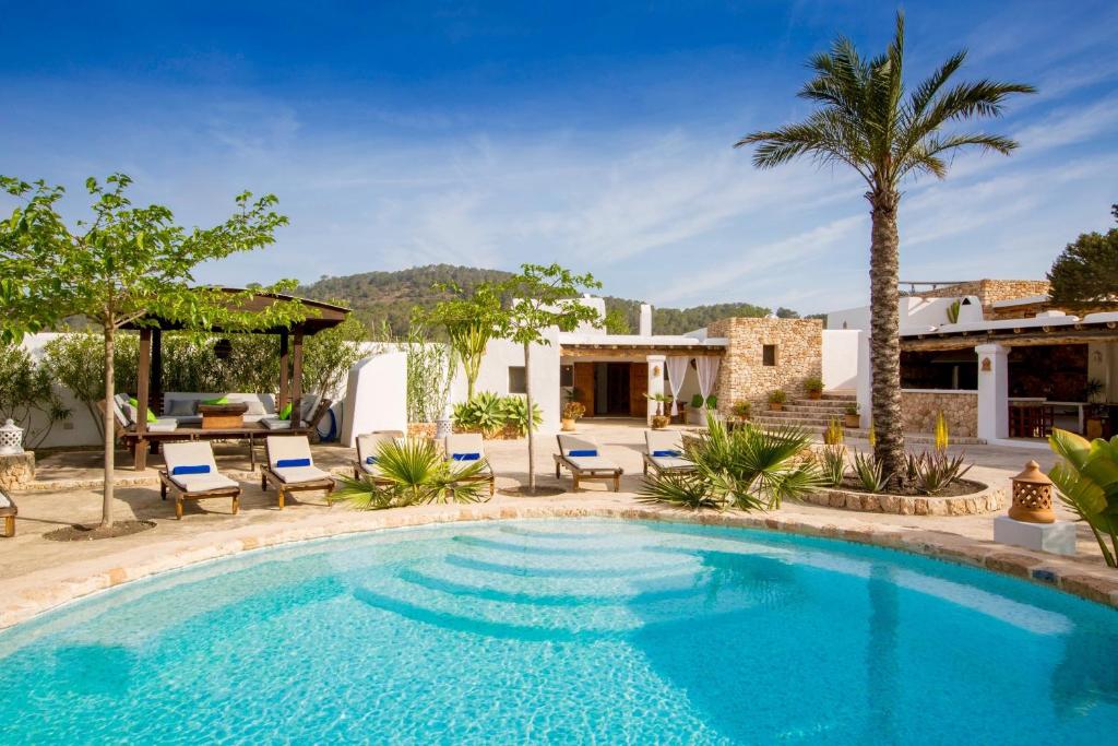 卡拉瓦德亚Villa Sa Paissa的一个带椅子的庭院和房子的游泳池