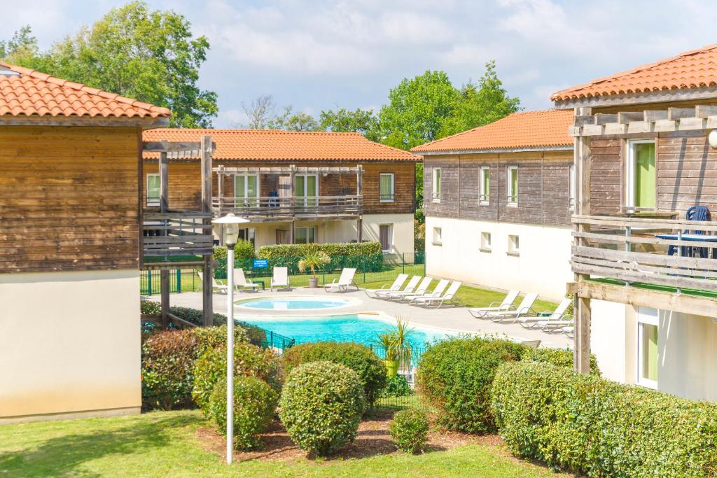 欧雷扬Lagrange Vacances Les Terrasses du Lac的庭院,设有游泳池和部分建筑