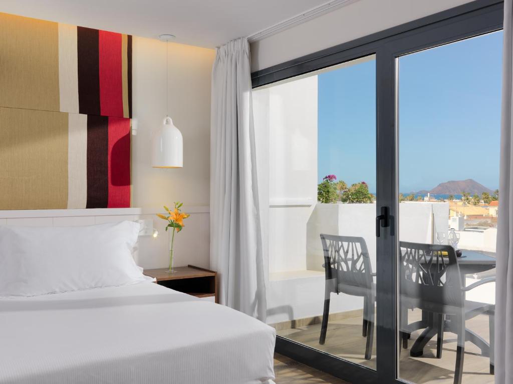 科拉雷侯H10海洋梦想精品酒店 - 仅限成人入住的一间卧室配有一张床铺和一张桌子,并设有一个阳台