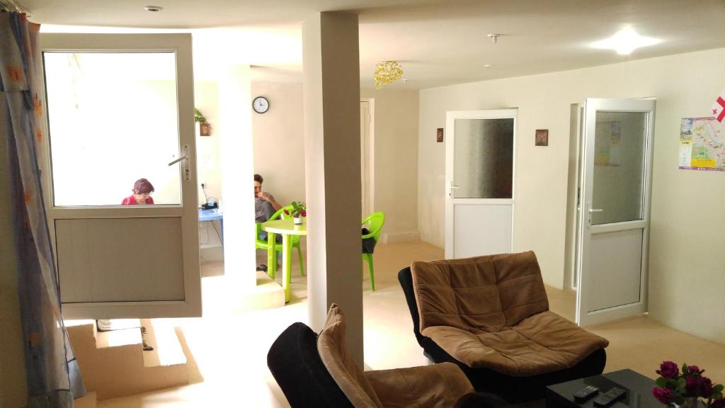第比利斯Comfort Plus的客厅配有两把椅子和电视