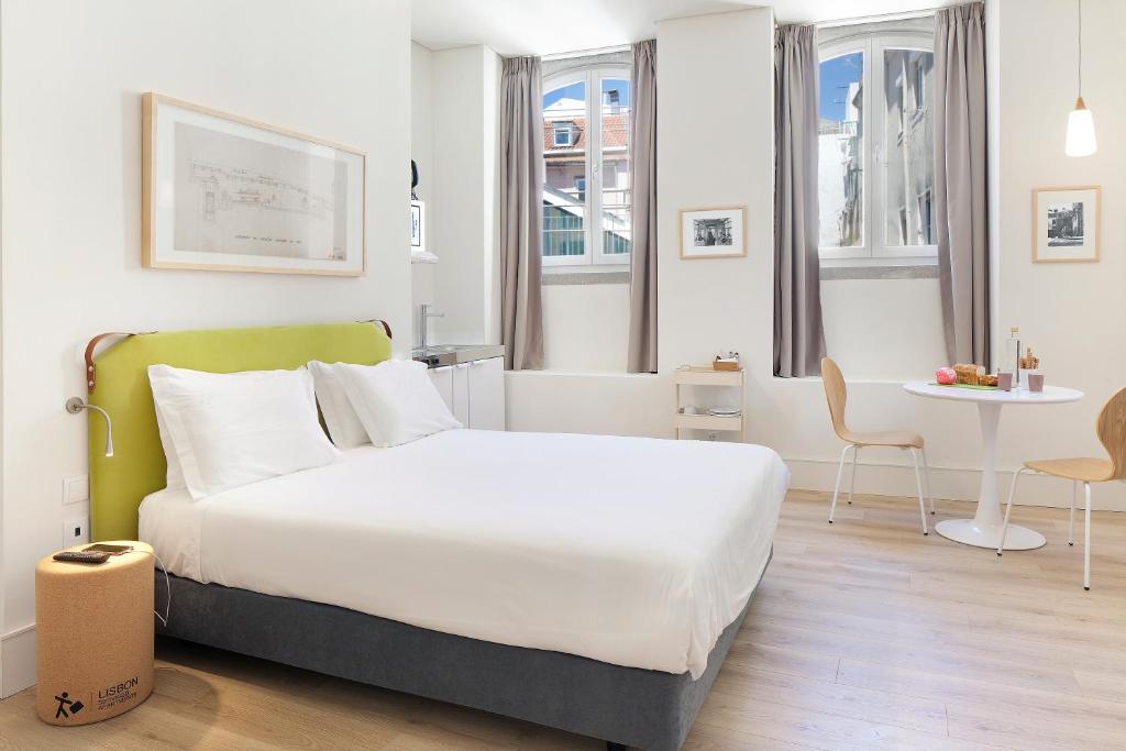 里斯本埃森萨尔比卡里斯本服务式公寓的酒店客房配有一张床铺和一张桌子。