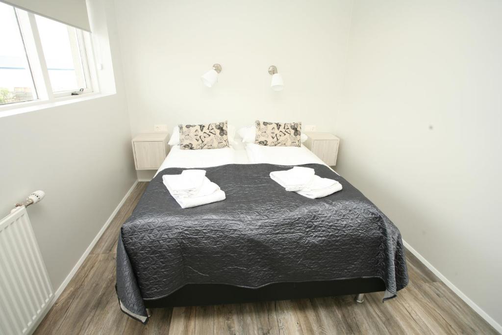 霍芬斯基亚博格公寓的一间卧室配有一张带黑色毯子和白色毛巾的床。
