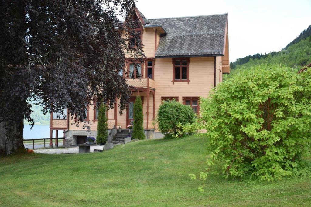 Luster多申加德乡村民宿的一座带绿色庭院的山丘上的房子