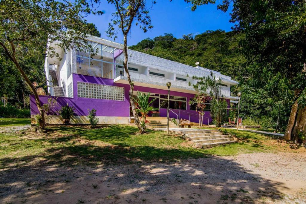 坎布里Casa Bacarirá - Floresta com Yoga e Café da Manhã Vegano的一面有紫色油漆的房子