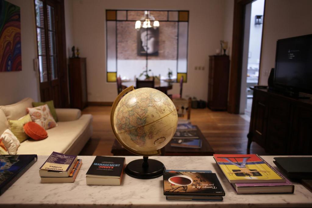 布宜诺斯艾利斯Cruce´s Hotel Boutique的客厅配有桌子、书架和书架