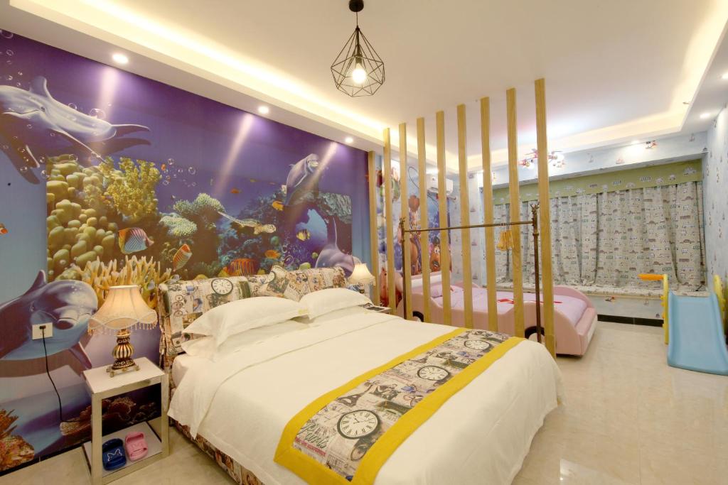 广州星悦遵品公寓长隆北门店的一间卧室配有两张床和一个水族馆壁画