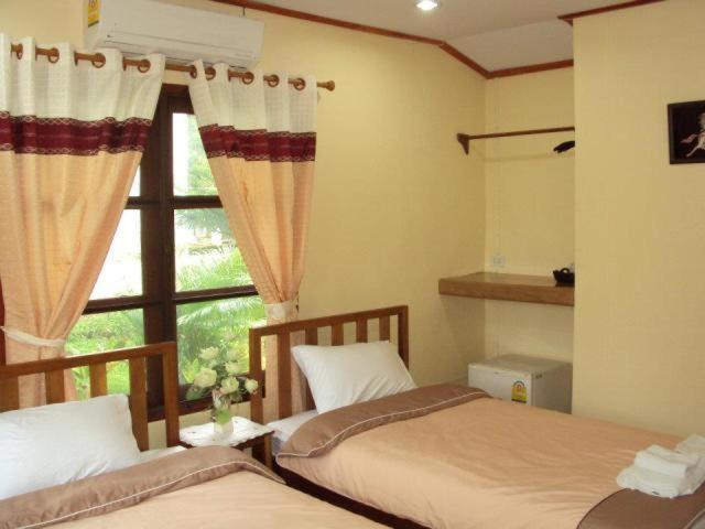 湄宏颂巴普哈多尔酒店的一间卧室设有两张床和窗户。