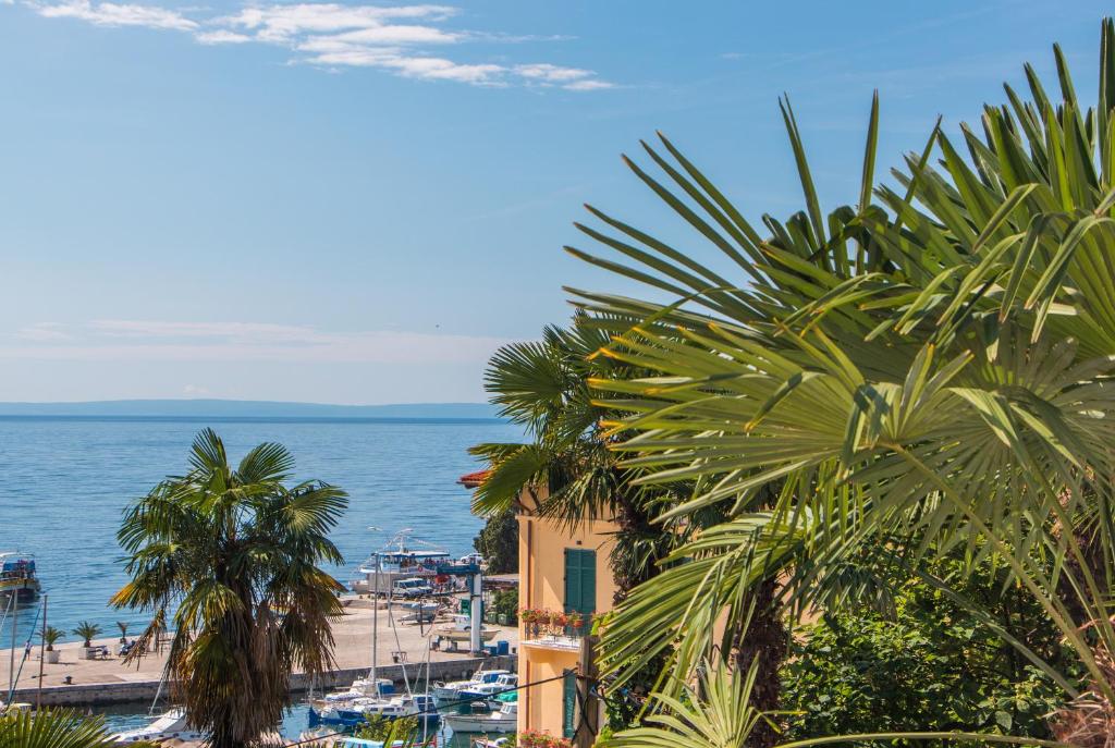 奥帕提亚Sunny Apartment Anamaria Opatija的享有棕榈树海滩和大海的景色