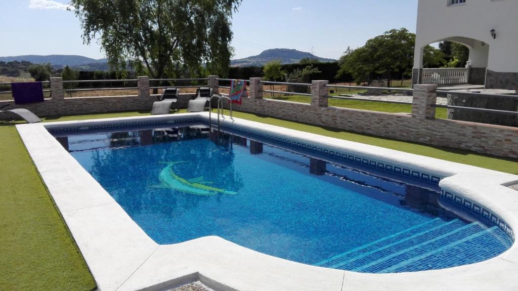 埃尔博斯克Casa Rural Entreparques的庭院里的一个蓝色海水游泳池