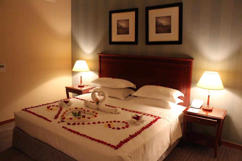 利雅德Manazel Al Diafa Serviced Apartments的一间卧室配有一张带天鹅的床