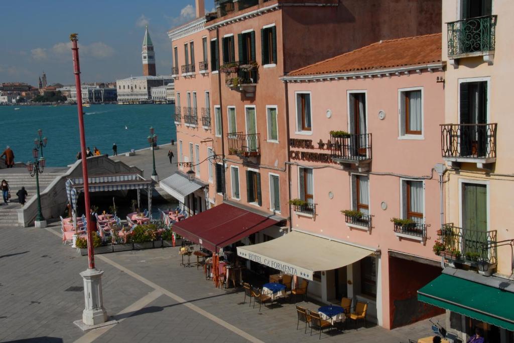 威尼斯卡弗蒙塔酒店的一群在水边设有桌椅的建筑