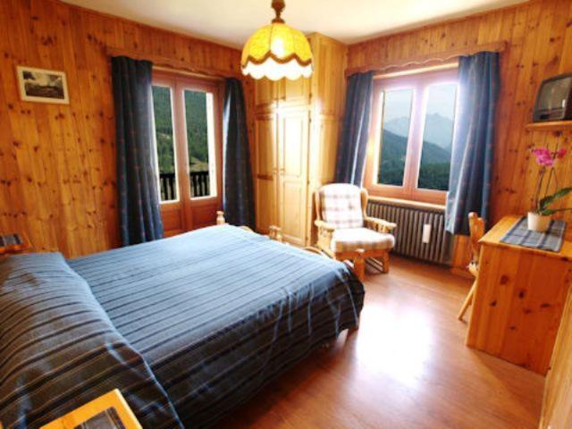 尚波吕克阿尔卑斯弗罗瑞酒店的一间卧室配有一张床、一把椅子和窗户。