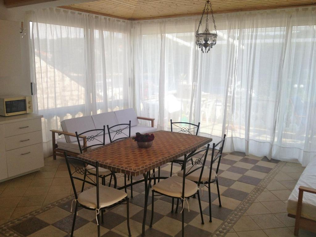 MolatApartments Mediteraneo的一间带桌椅和窗户的用餐室
