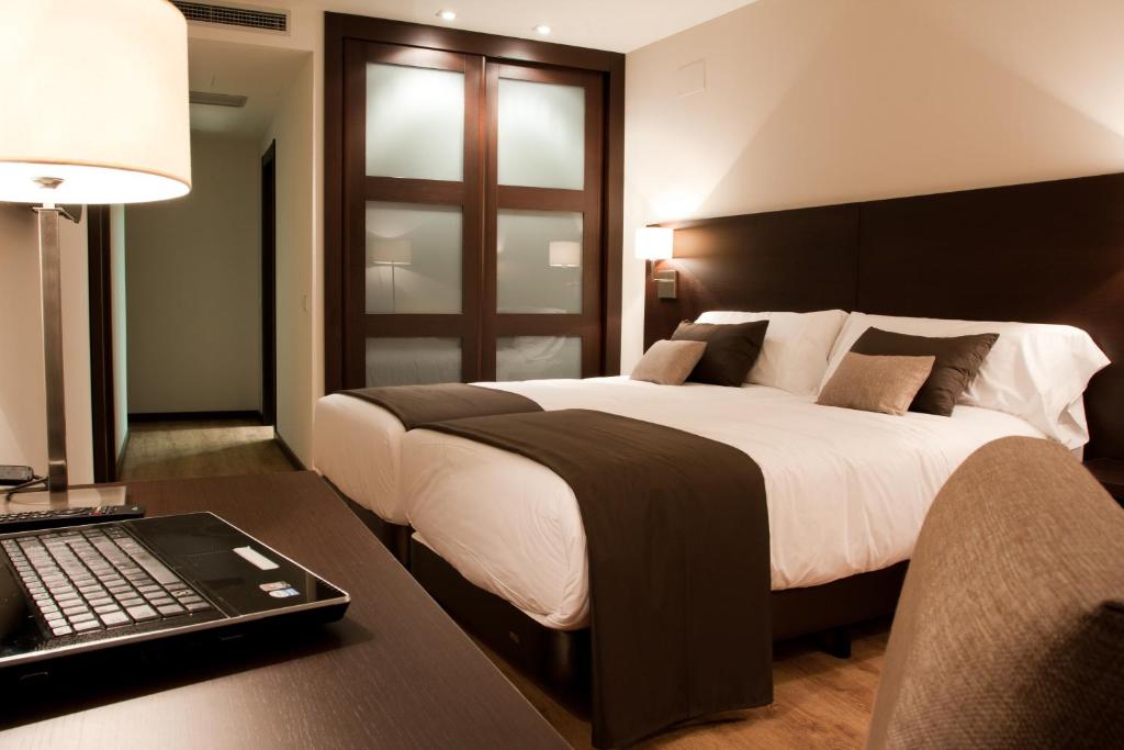 托梅略索帕洛玛酒店的一间卧室配有一张床和一张带笔记本电脑的书桌