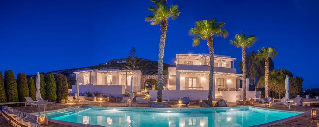 阿吉亚艾里尼帕罗Villas Agia Irini Cove的一座在晚上设有游泳池的大房子