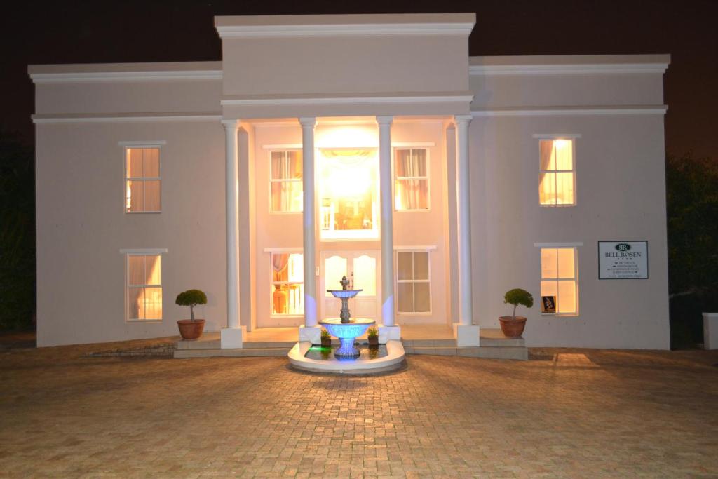 贝尔维尔Bell Rosen Guest House的一座白色的建筑,前面有一个喷泉