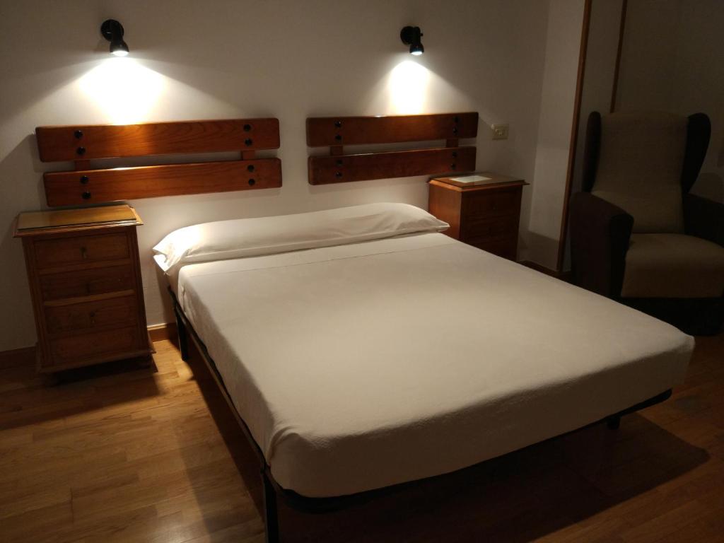 普韦布拉桑纳比亚佩拉莱斯酒店的卧室配有床、椅子和灯