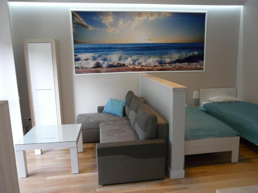 斯维诺乌伊希切Apartament Bluesky的客厅配有沙发和墙上的绘画