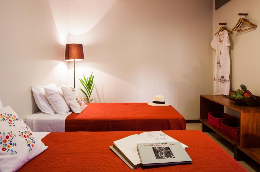 萨尔瓦多卡萨达维多利亚旅馆 的酒店客房带两张床,一张桌子上写着一本书