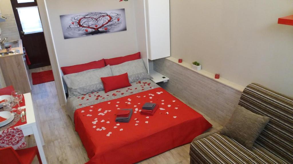 锡拉库扎Mishalay Apartment的小房间设有红色的床和沙发