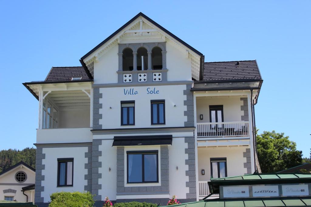 沃尔特湖畔佩莎赫Seeappartements Villa Sole的一座白色的大建筑,上面有村里出售的字眼