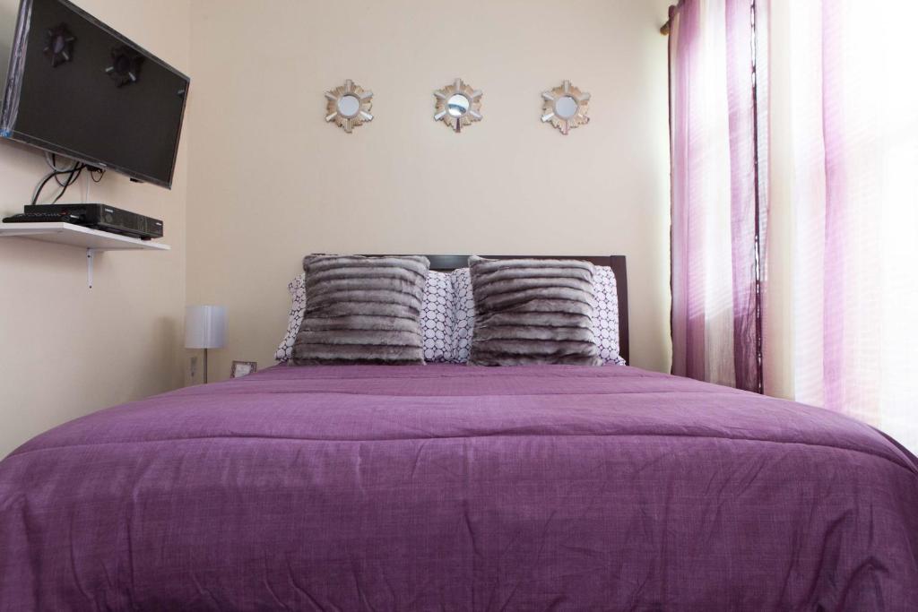布朗克斯布朗克斯一卧室和两卧室公寓的一间卧室配有一张紫色床,墙上配有电视