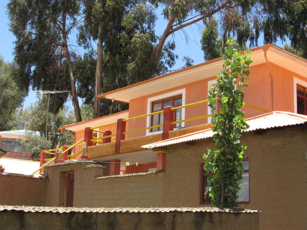 奥科苏尤Titicaca Chaska Wasi Amantani的一座橙色的房子,上面设有一个阳台
