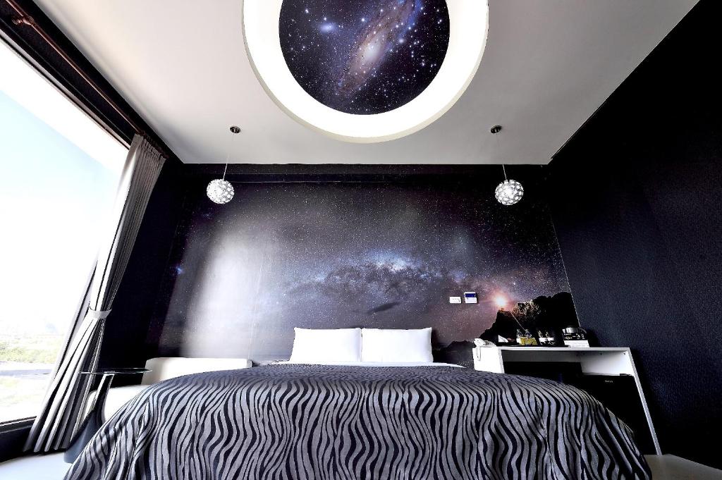 埔里可可摩铁时尚旅店的一间卧室设有一张床和一个享有宇宙美景的窗户