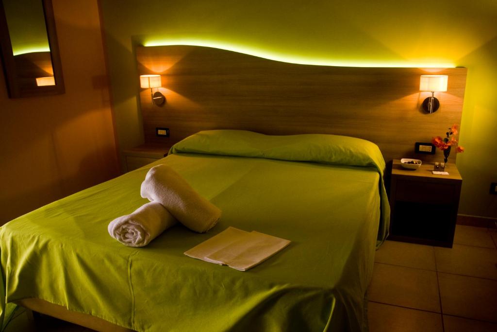 墨西拿B&B Liberty的一间卧室配有绿床和2条毛巾