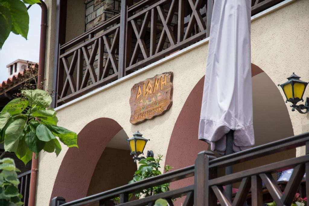 欧拉努波利斯Dione Apartments的建筑一侧的标牌,上面有雨伞