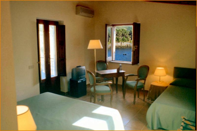 马拉泰亚伊利西尼酒店的卧室配有一张床和一张桌子及椅子