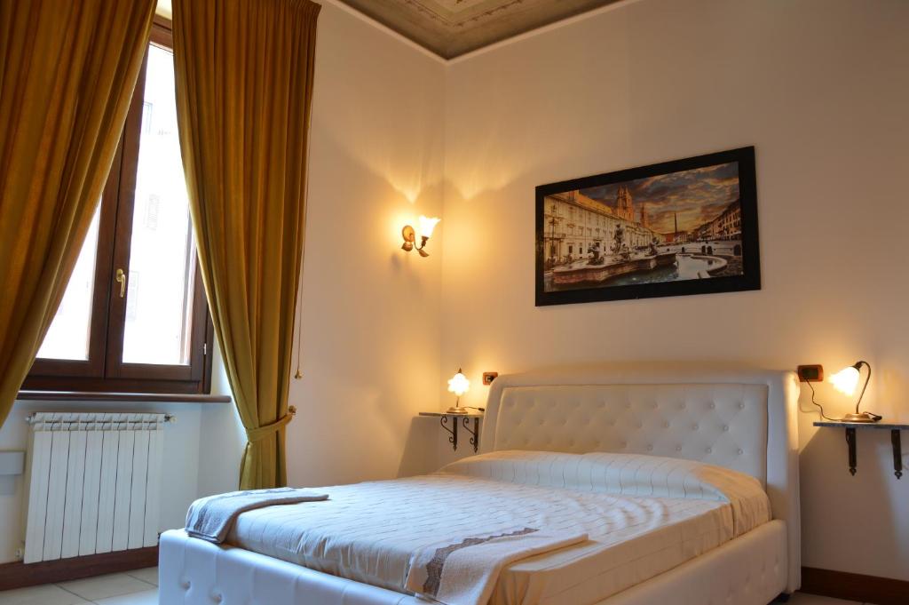 罗马罗马索诺因菲尼多住宿加早餐旅馆的卧室配有一张床,墙上挂有绘画作品