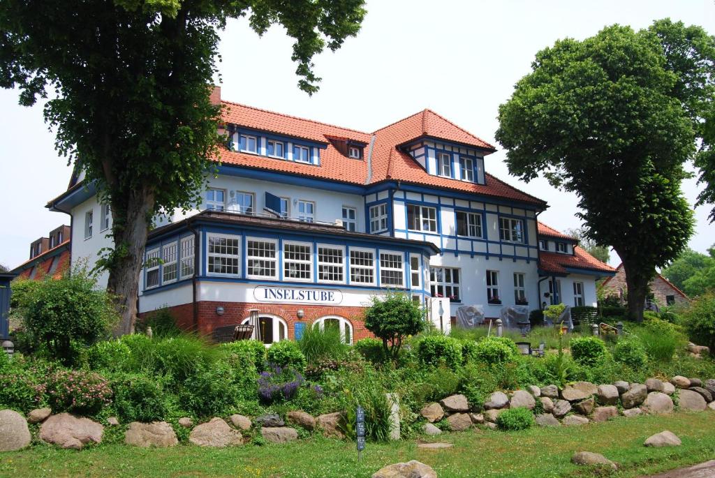 克洛斯特Ferienwohnung auf Hiddensee im Ort Kloster的一座白色的大建筑,有红色的屋顶