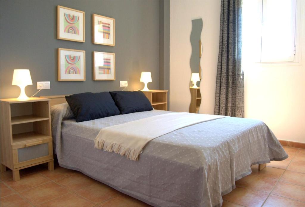 拉安蒂拉Apartamentos BeSlow La Antilla的一间卧室配有一张带两盏灯的床。