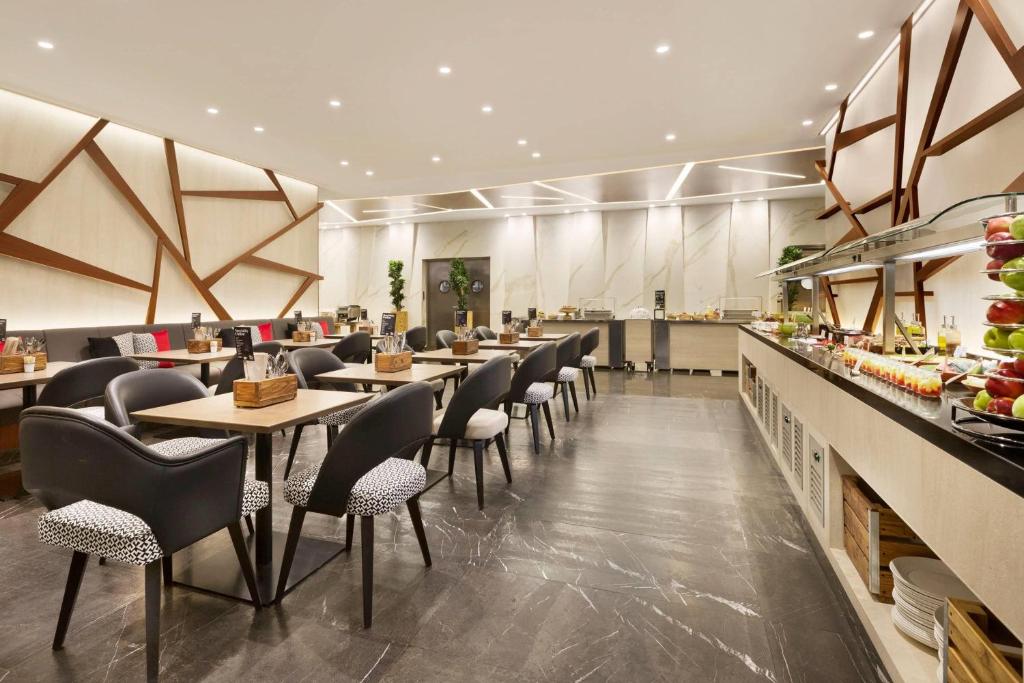 迪拜迪拜温德姆特瑞普酒店的有桌椅的餐厅和自助餐厅