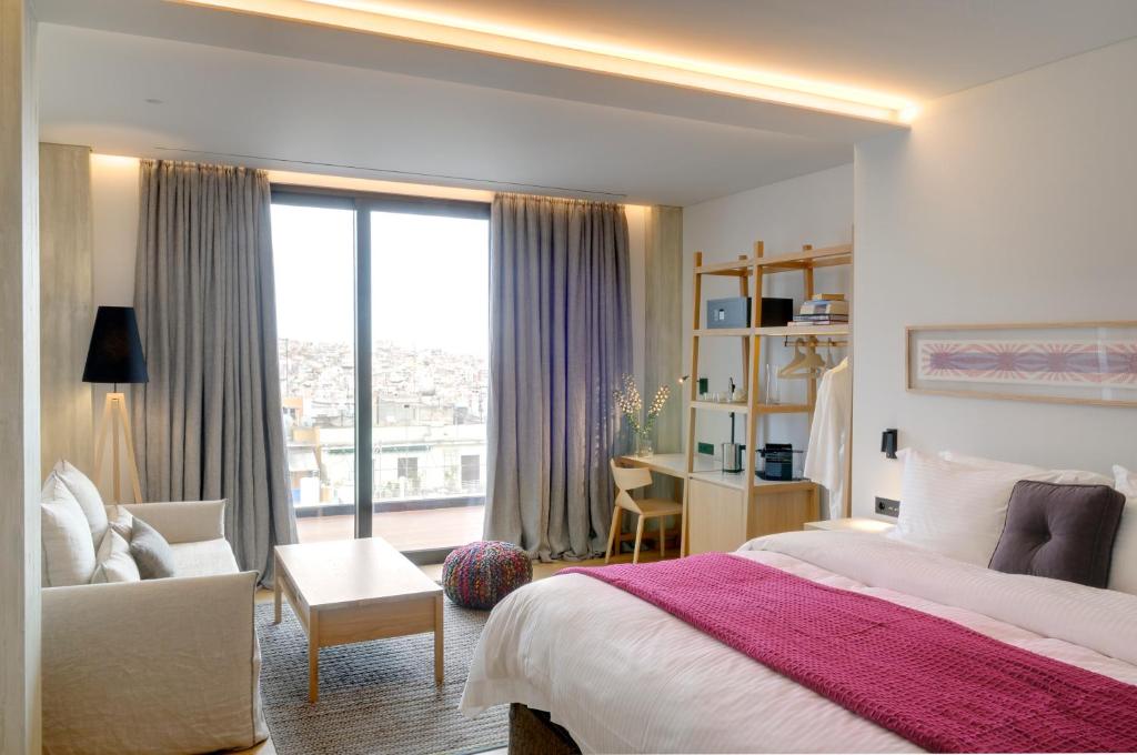 雅典雅典可可玛特酒店的卧室配有床、椅子和窗户。