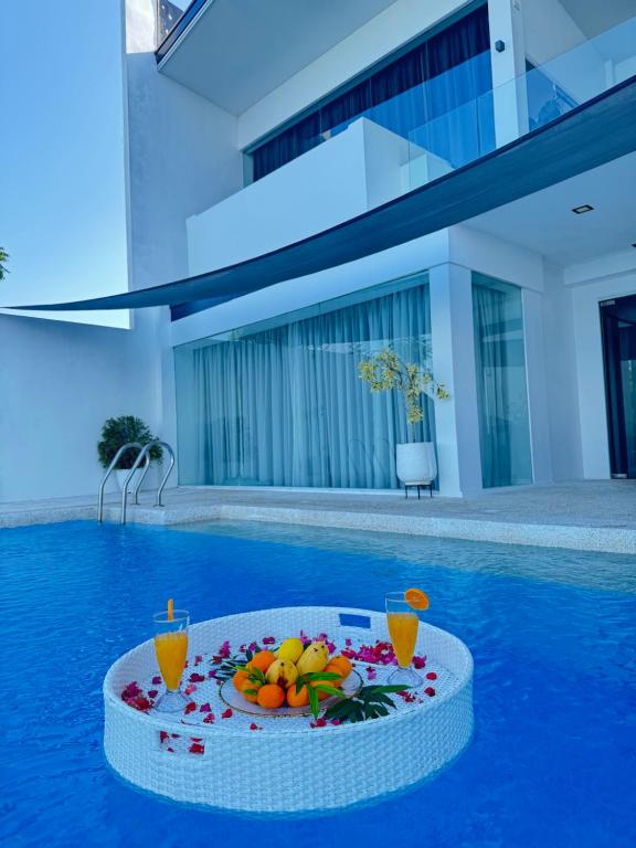 道伊斯Epic Suites Bohol ADULTS ONLY的游泳池里的桌子上放着水果盘