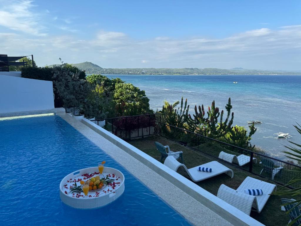 道伊斯Epic Suites Bohol ADULTS ONLY的度假村的游泳池，水边放着一碗食物