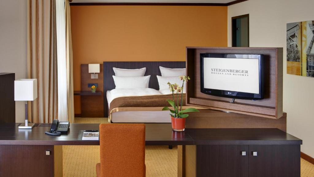 多特蒙德多特蒙德施泰根博阁酒店的酒店客房配有一张床和一张书桌及一台电视
