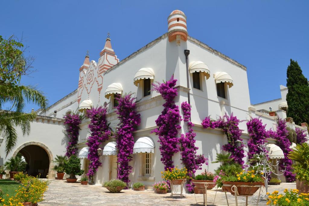 库特罗菲安诺三吉奥吉奥度假酒店 的一座在前面布满紫色花的建筑