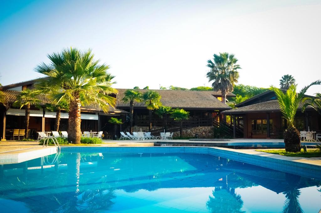 安帕鲁坎托达斯塔环保度假村的棕榈树屋前的游泳池