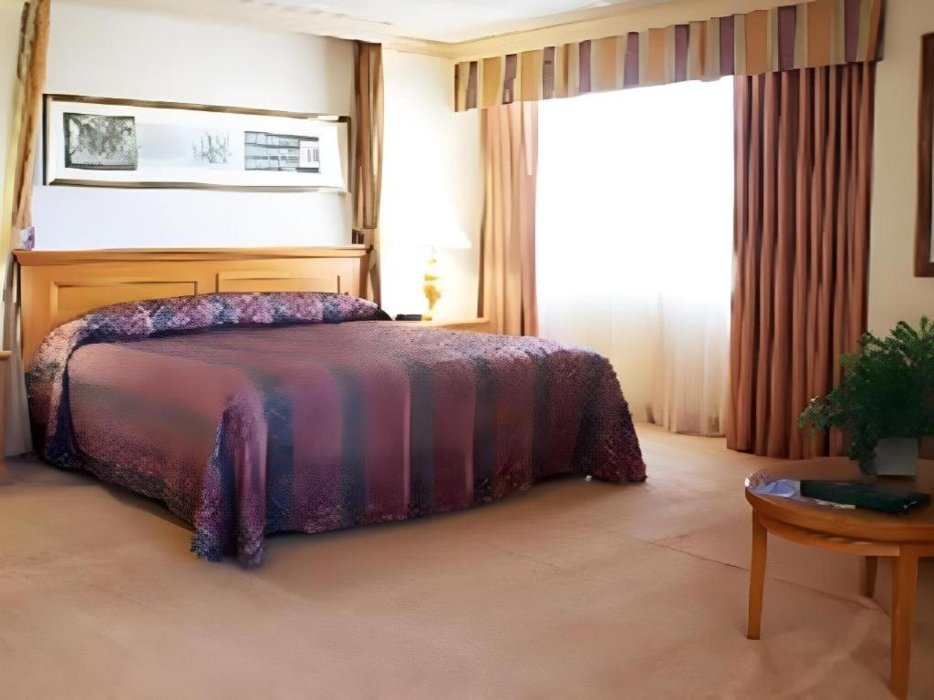 里诺Harrahs Hotel Reno的一间卧室，里面有一张床、一张桌子和一扇窗户