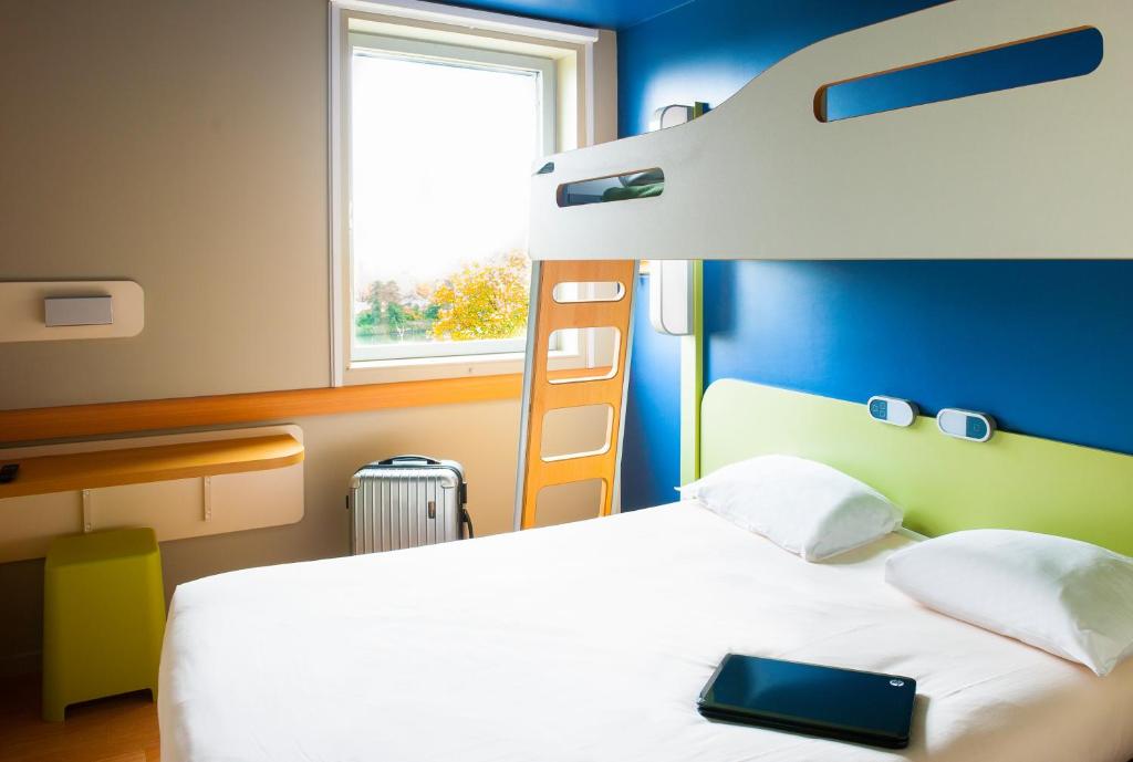 塞尔吉Ibis Budget Cergy St Christophe的一间卧室配有一张床和一张双层床。