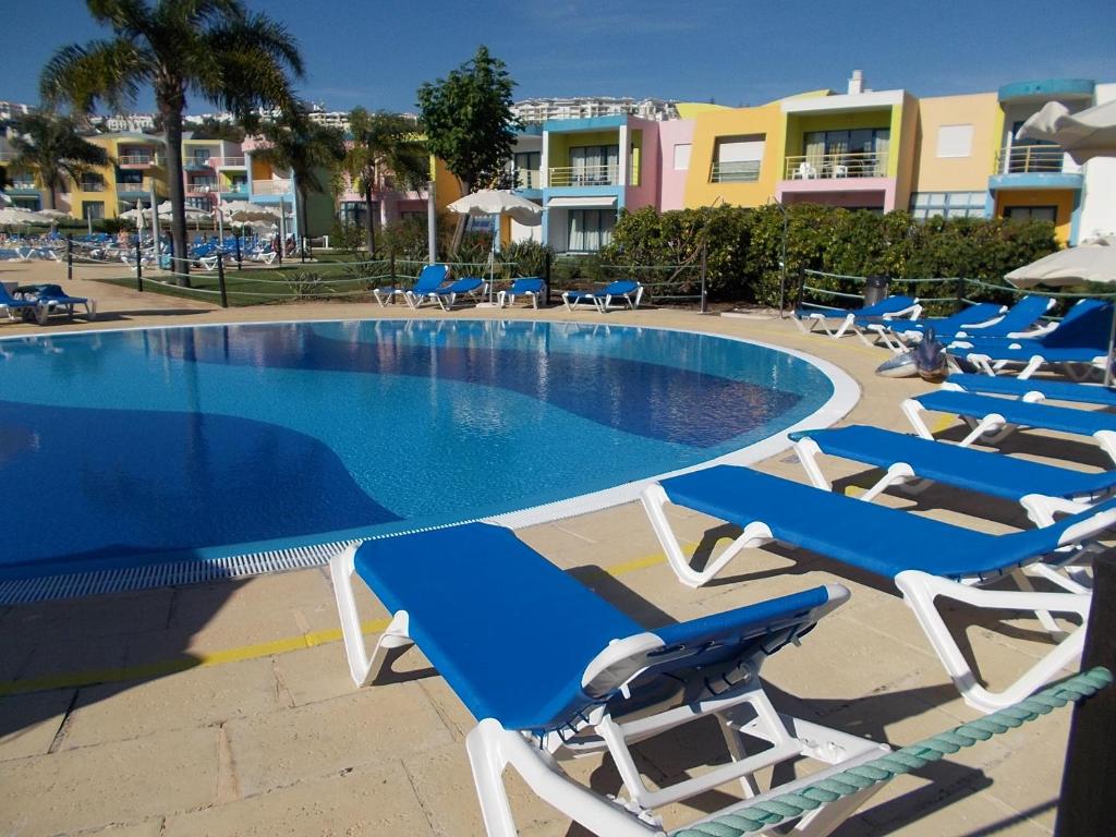 阿尔布费拉T1 e T2 Marina Albufeira apartments的一组躺椅和一个游泳池