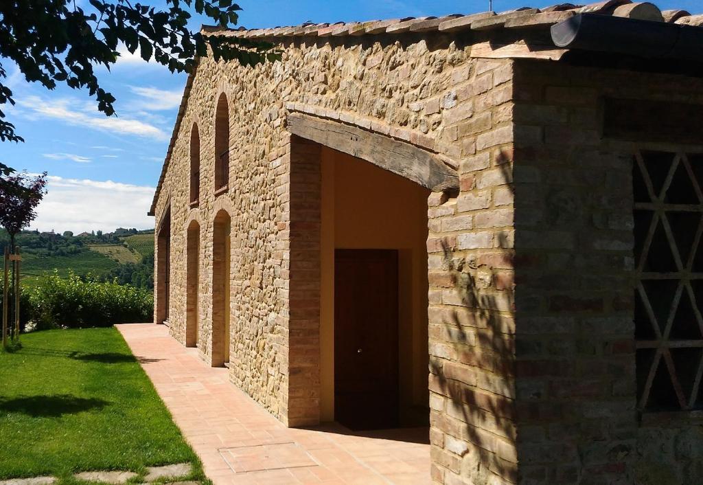 圣吉米纳诺卡帕纳1826农家乐的享有石头建筑的外部景色,设有大门廊