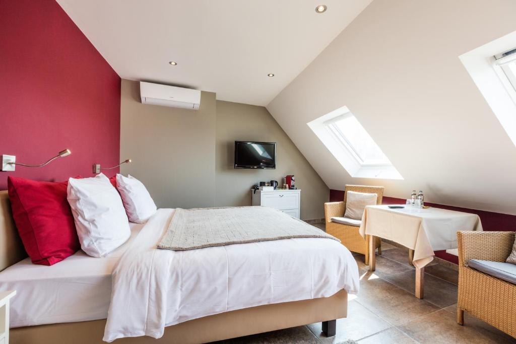 波佩林赫安菲拉宾馆的一间卧室设有一张带红色墙壁的大床